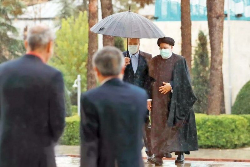 عکسی متفاوت از رؤسای قوه مجریه و مقننه قالیباف و رئیسی در هوای بارانی زیر یک چتر !